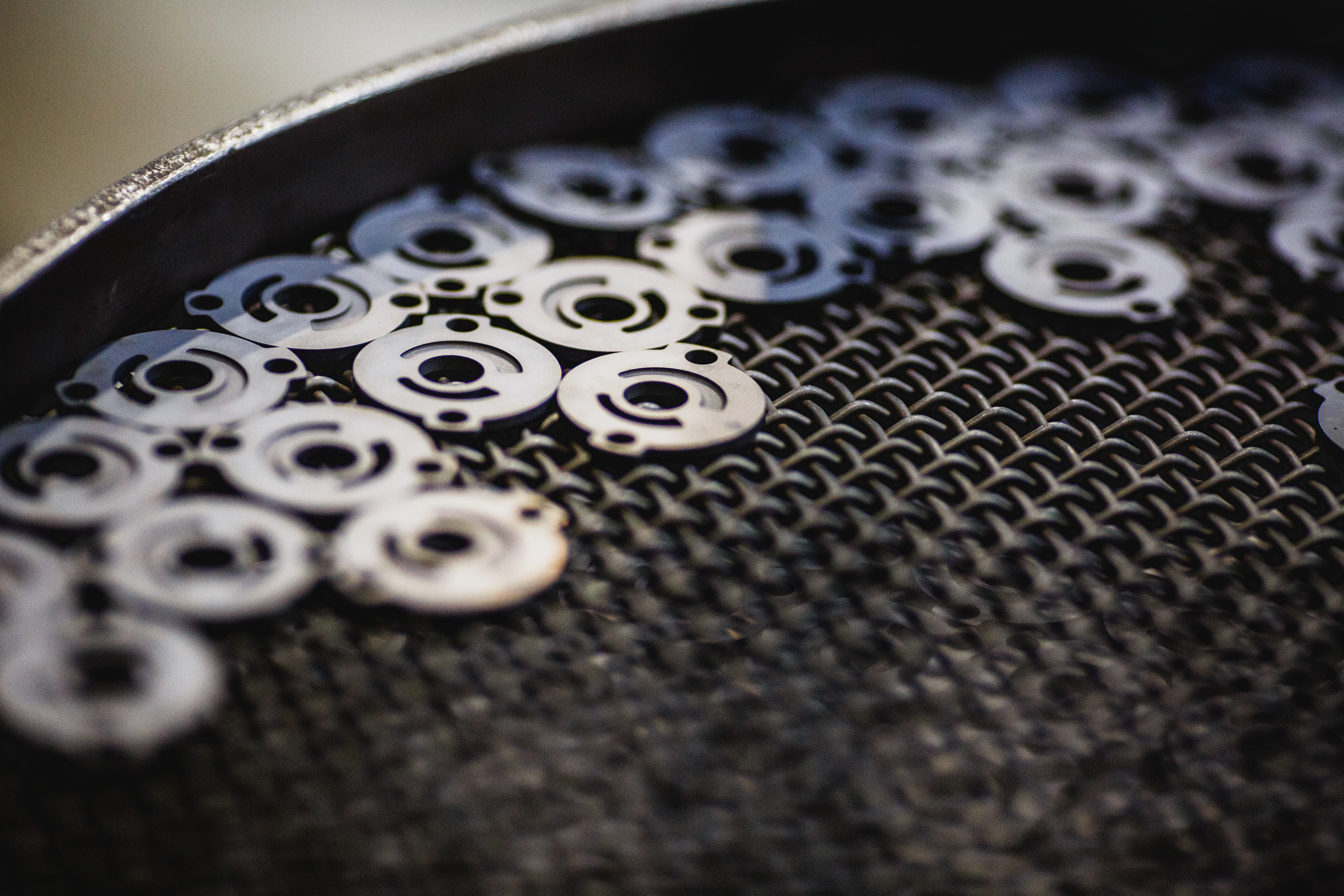 Small metal circular parts on wire mesh surface